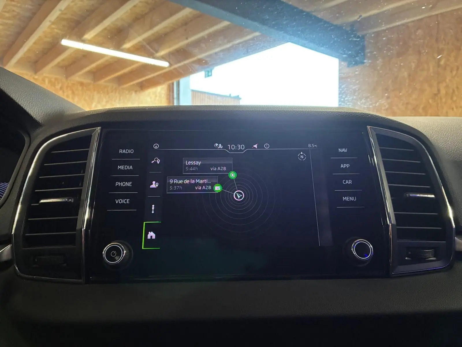 Écran central tactile du Skoda Karoq 2023 noir, affichant le GPS avec menu latéral et commandes autour.
