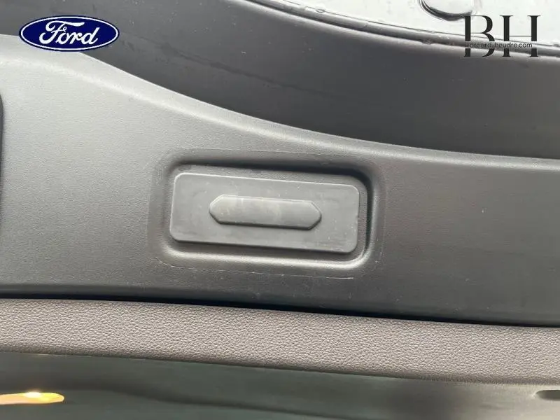 Détail du bouton d'ouverture de coffre sur le hayon intérieur d'un Renault Espace noir étoilé, vue rapprochée.