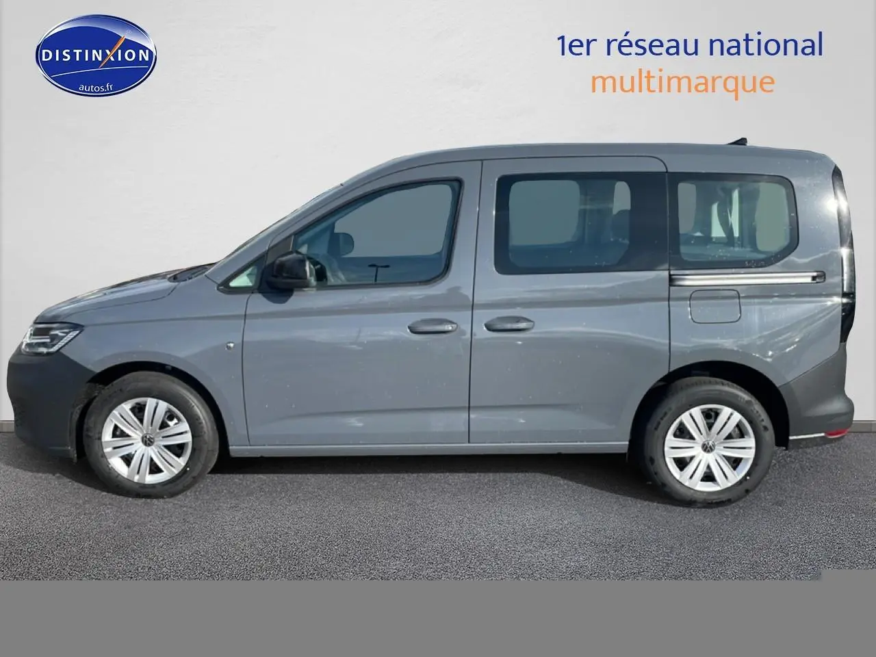 Profil droit d'un Volkswagen Caddy gris pur 2025 avec vitres teintées et jantes alliage.