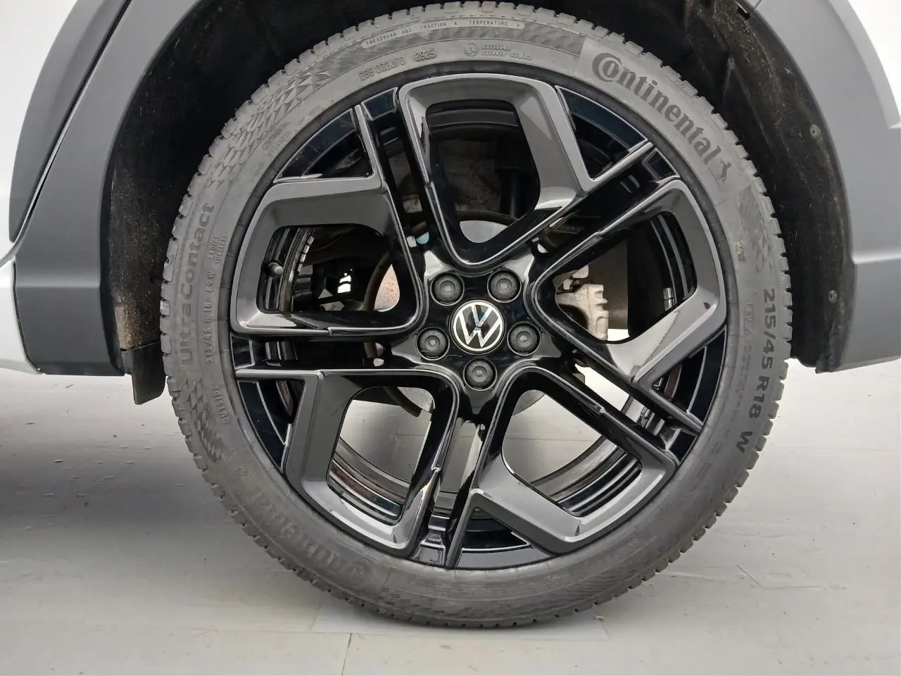 Gros plan sur la jante noire en alliage léger 18 pouces York du Volkswagen Taigo blanc pur, avec pneu Continental.