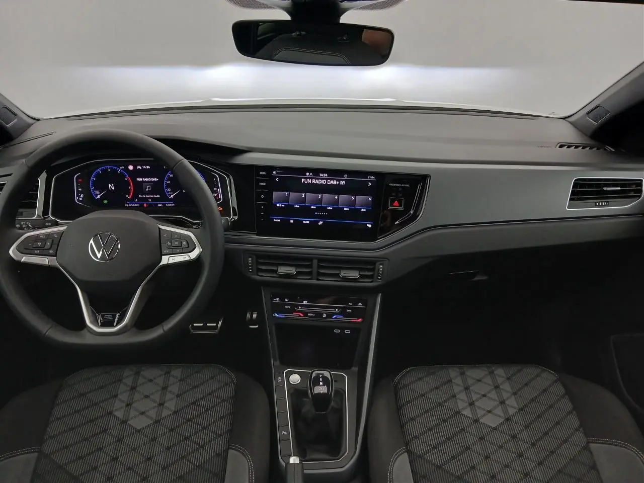 Vue intérieure avant du Volkswagen Taigo 2025, tableau de bord noir avec écran tactile central et volant multifonctions.