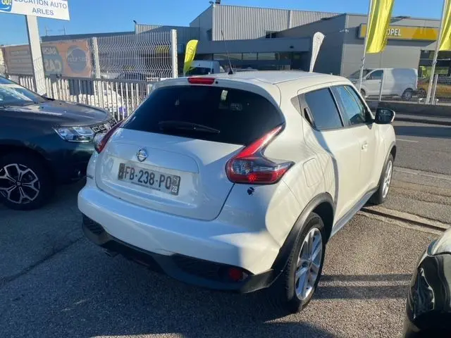 Vue 3/4 arrière d'un Nissan Juke blanc 2018 version 1.5 110 CH N-Connecta, avec feux arrière caractéristiques en boomerang.