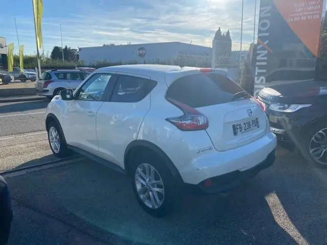 Nissan Juke blanc en 3/4 arrière droit, version 1.5 110 CH N-CONNECTA de 2018, garé en extérieur au soleil.
