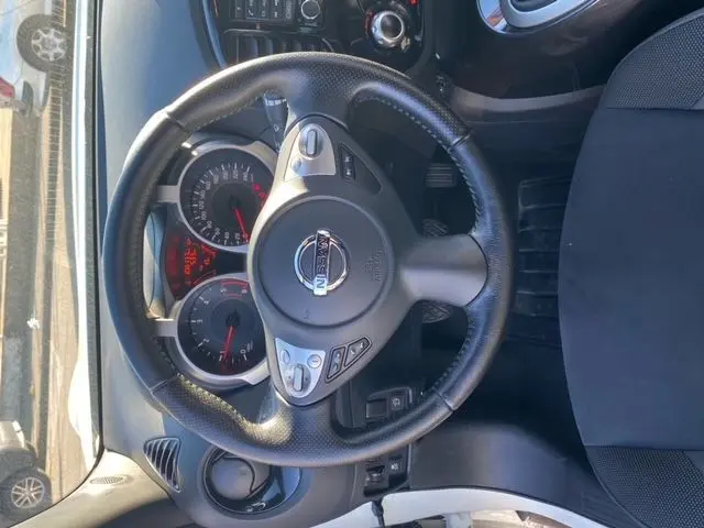 Vue intérieure centrée sur le volant noir du Nissan Juke 1.5 110 CH N-Connecta 2018 avec tableau de bord et sièges gris.