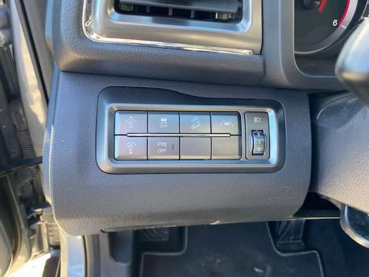 Panneau de commandes latéral gauche du tableau de bord du SsangYong Tivoli gris foncé 2021, avec boutons de réglage et molette.