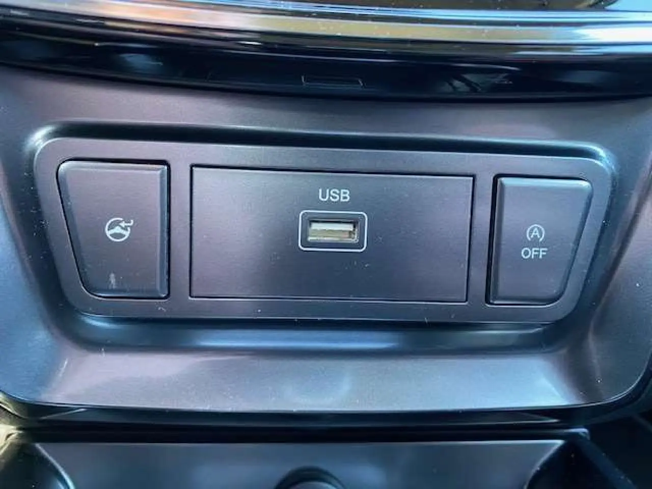 Gros plan sur la prise USB et les boutons de commande noirs dans l'habitacle du SsangYong Tivoli gris foncé 2021.