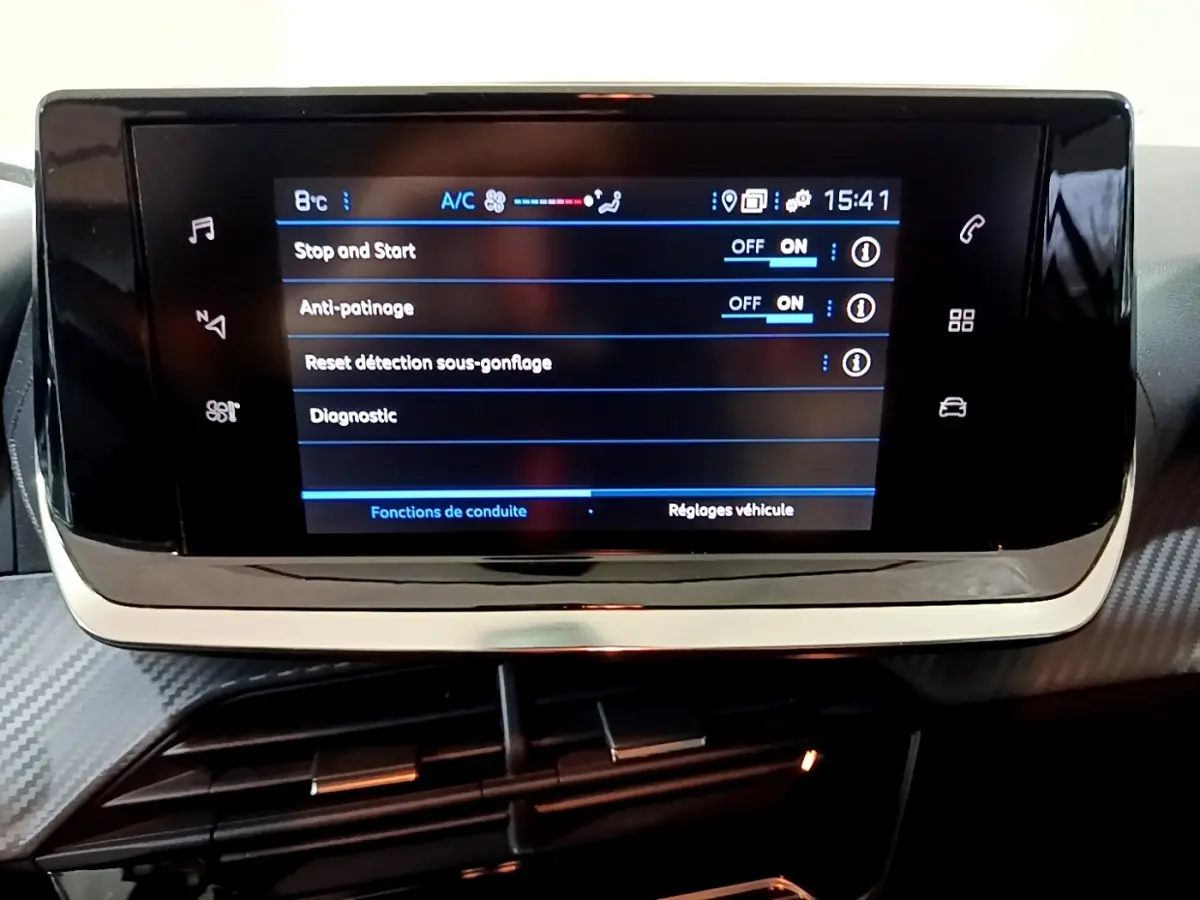Écran tactile central affichant les réglages de conduite dans l'habitacle d'une Peugeot 208 blanche de 2021.