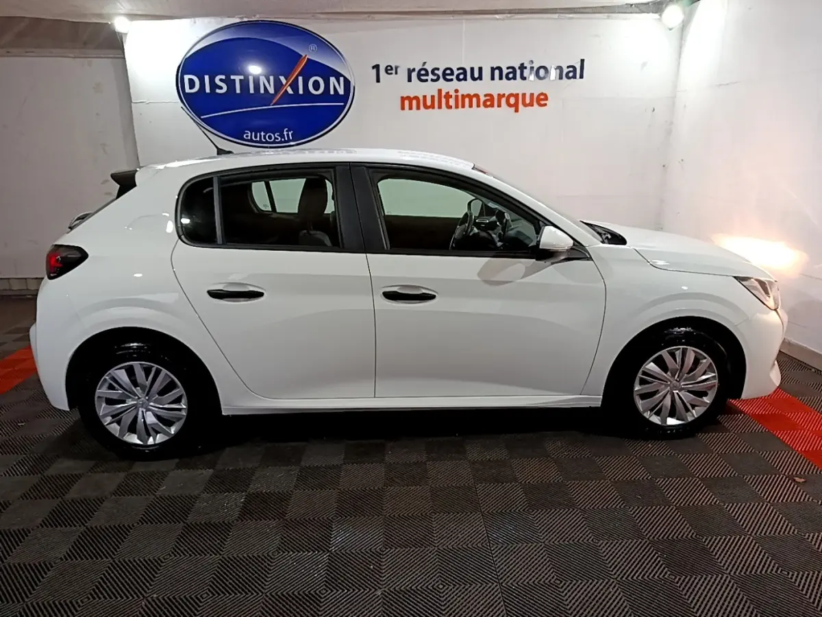 Vue de profil côté gauche d'une Peugeot 208 blanche 2021 dans un showroom avec sol à damier et mur blanc.