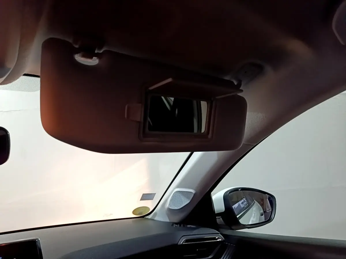Vue intérieure côté gauche du pare-soleil avec miroir ouvert dans une Peugeot 208 blanche de 2021.