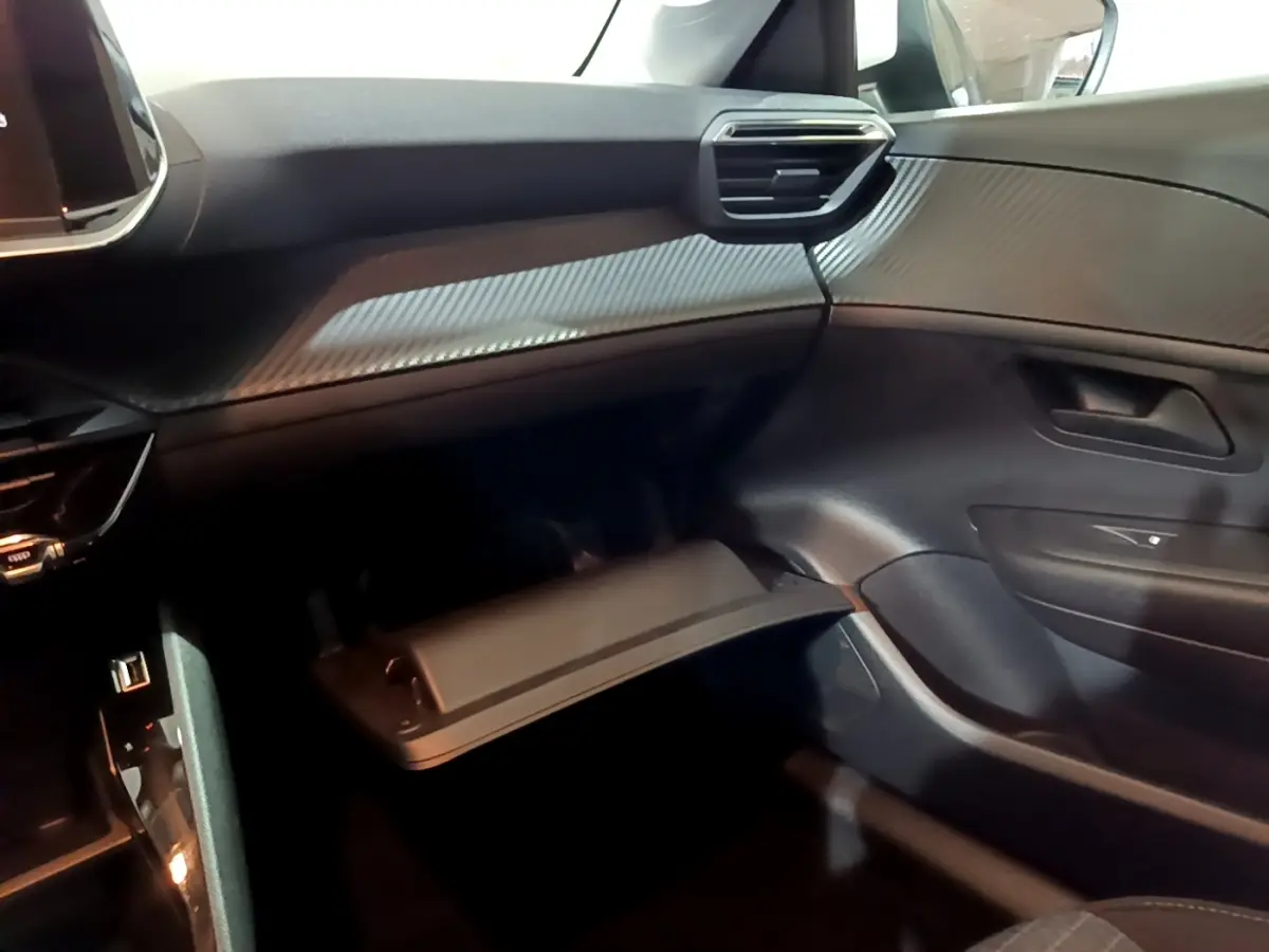 Vue intérieure côté passager de la Peugeot 208 1.5 BlueHDi 100 S&S Premium 2021, tableau de bord noir avec finition texturée.