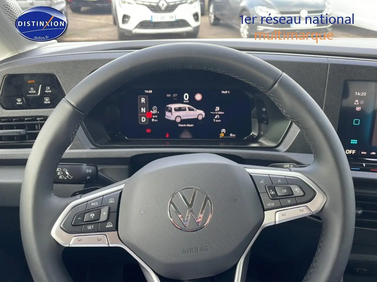 Vue intérieure centrée sur le volant cuir multifonction du Volkswagen Caddy blanc avec tableau de bord numérique.