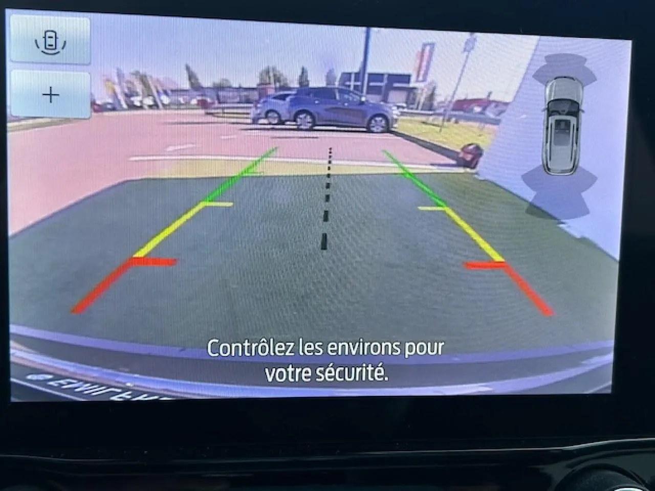 Vue caméra de recul du Ford Puma gris Magnetic montrant l'arrière et les lignes de guidage colorées au parking.