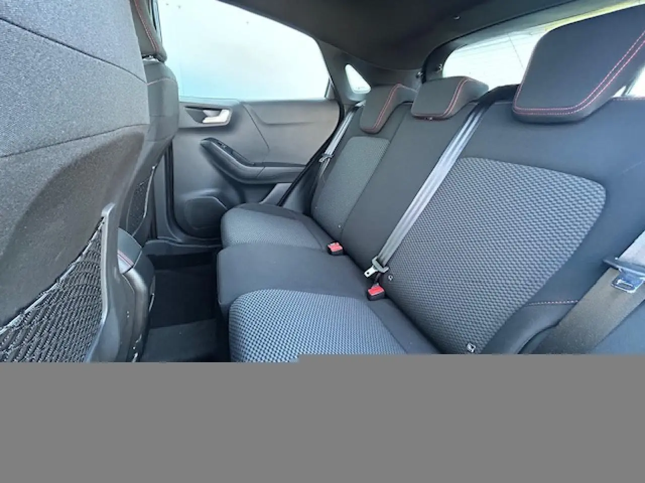 Vue intérieure arrière droite de la banquette noire avec surpiqûres rouges du Ford Puma ST-Line 2023.