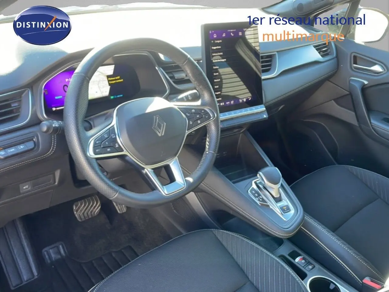 Vue intérieure côté conducteur de la Renault Symbioz 2025, tableau de bord noir avec écran tactile vertical et volant multifonction.