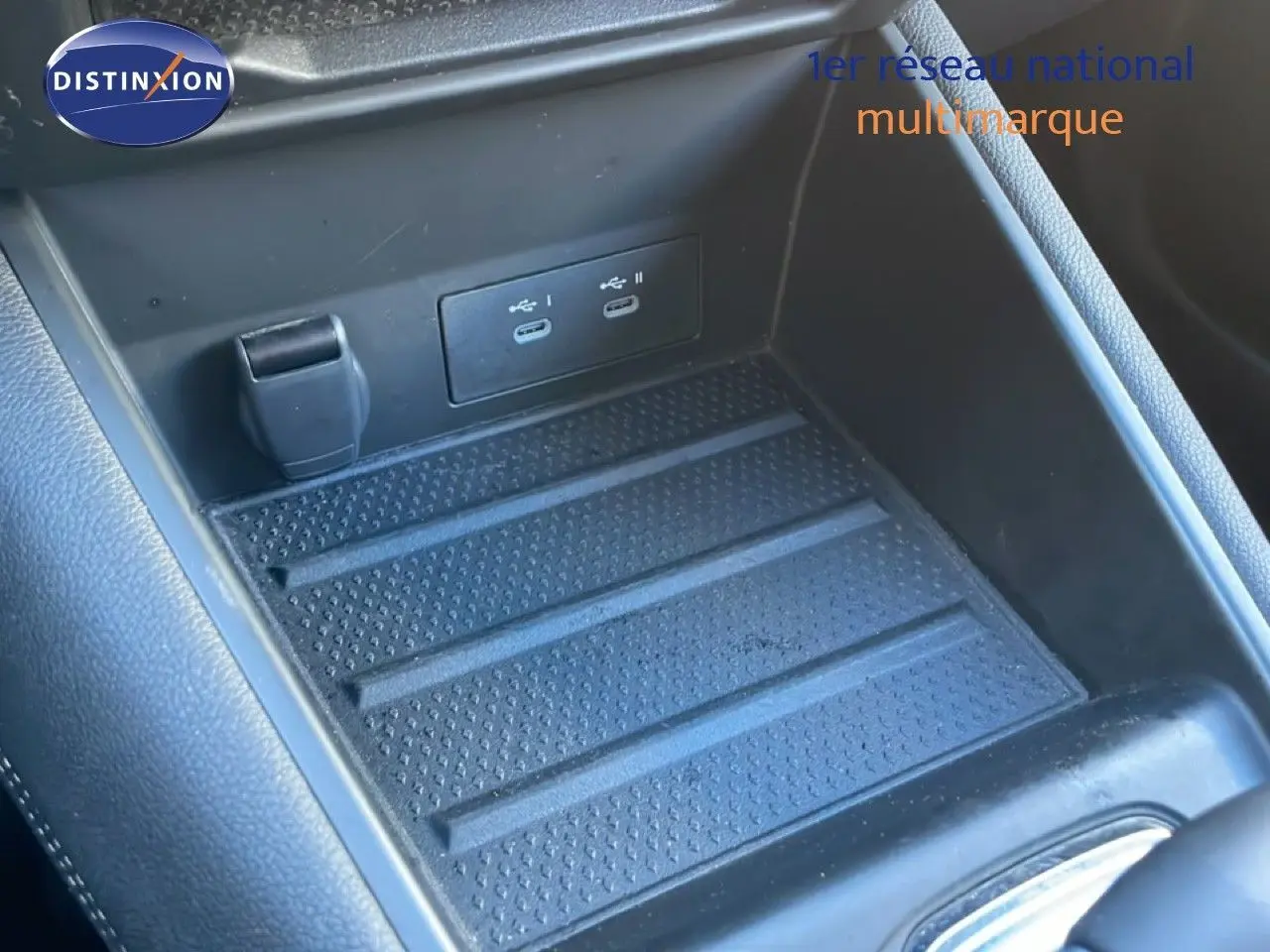 Gros plan sur la console centrale noire du Renault Symbioz 2025, montrant les ports USB-C et un espace de rangement.