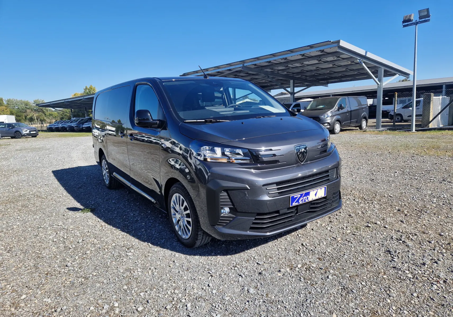 Peugeot Expert Cabine Approfondie gris titane vu en 3/4 avant droit sur un parking ensoleillé.