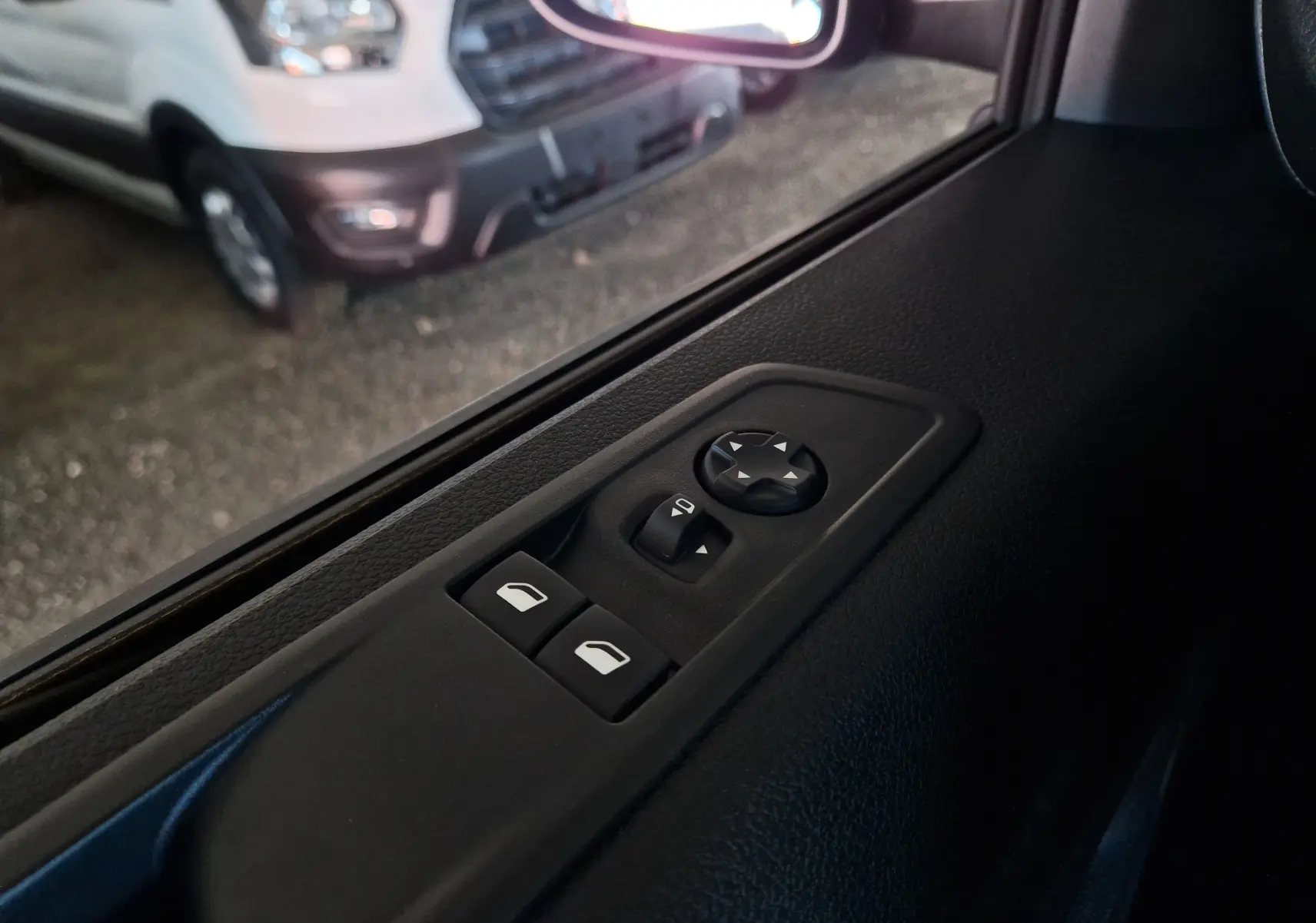 Commande des vitres et réglage des rétroviseurs sur la porte côté gauche d'un Peugeot Expert gris titane, vue intérieure rapprochée.