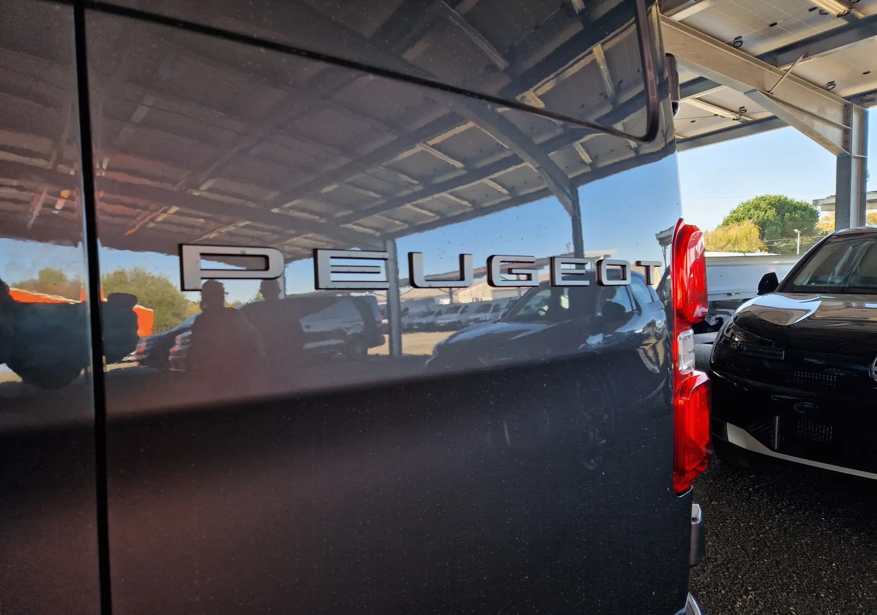 Gros plan sur l'arrière droit gris titane du Peugeot Expert Cabine Approfondie 2025 avec logo Peugeot en relief.