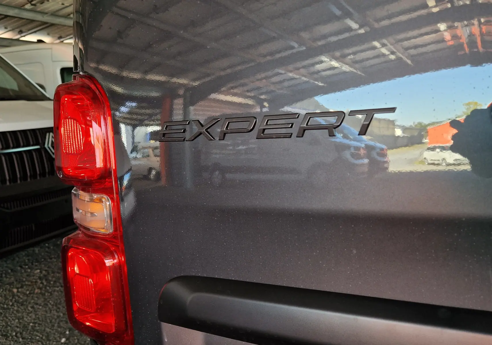 Gros plan sur l'arrière gauche gris titane du Peugeot Expert avec le logo "EXPERT" et le feu arrière rouge visible.