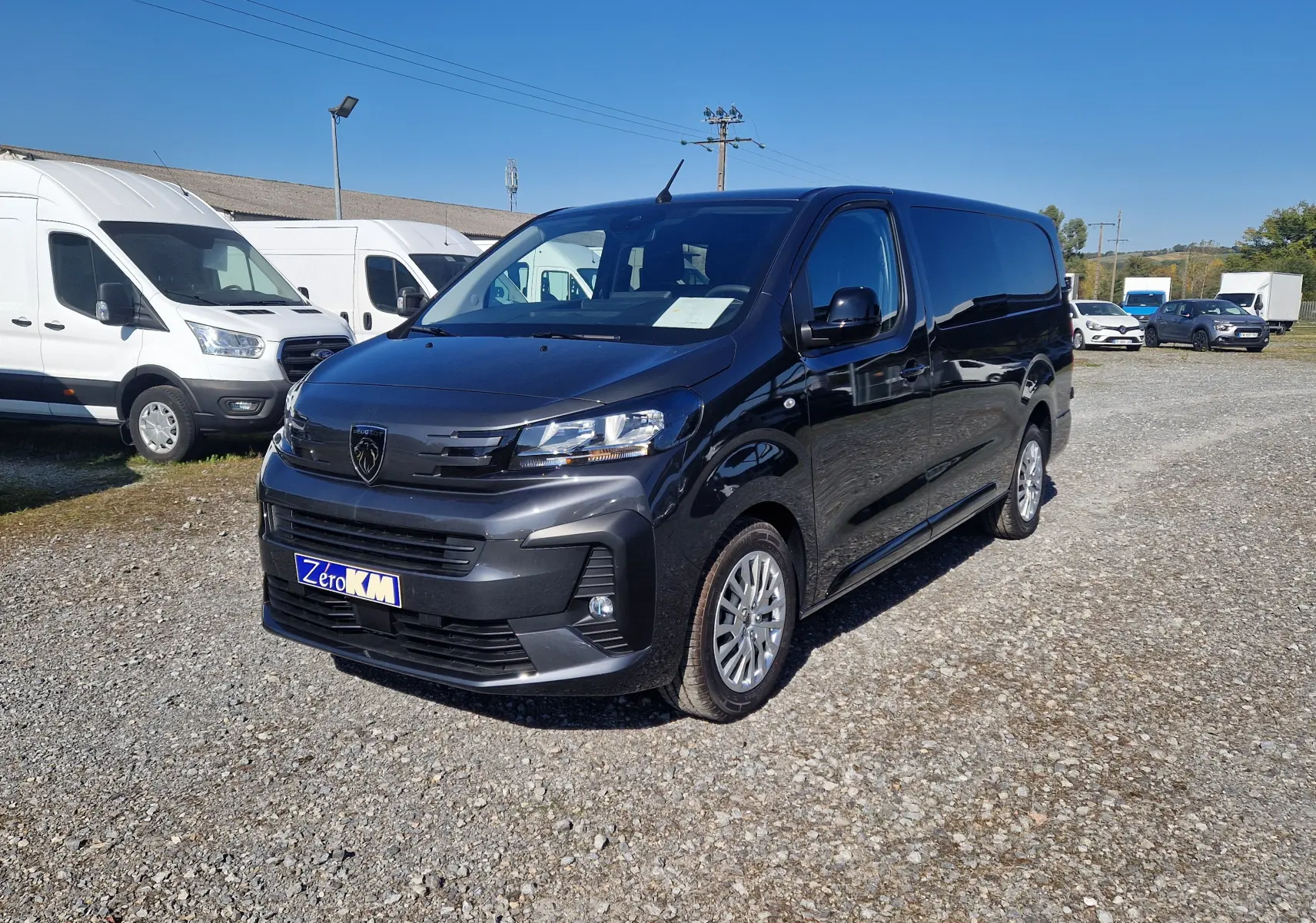 Vue 3/4 avant droite d'un Peugeot Expert Cabine Approfondie gris titane avec calandre noire et jantes argentées.
