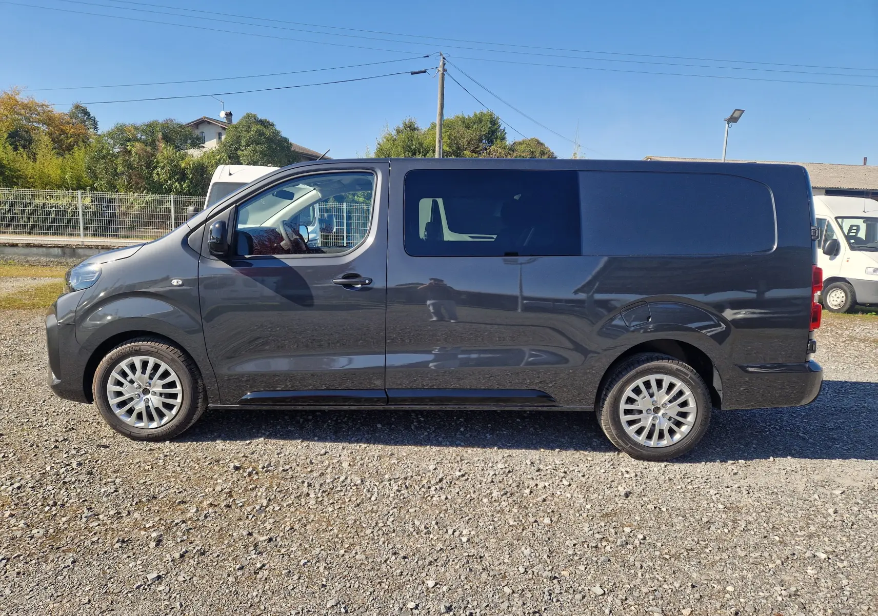 Peugeot Expert XL gris titane vu de profil côté gauche, avec cabine approfondie et vitres teintées arrière.