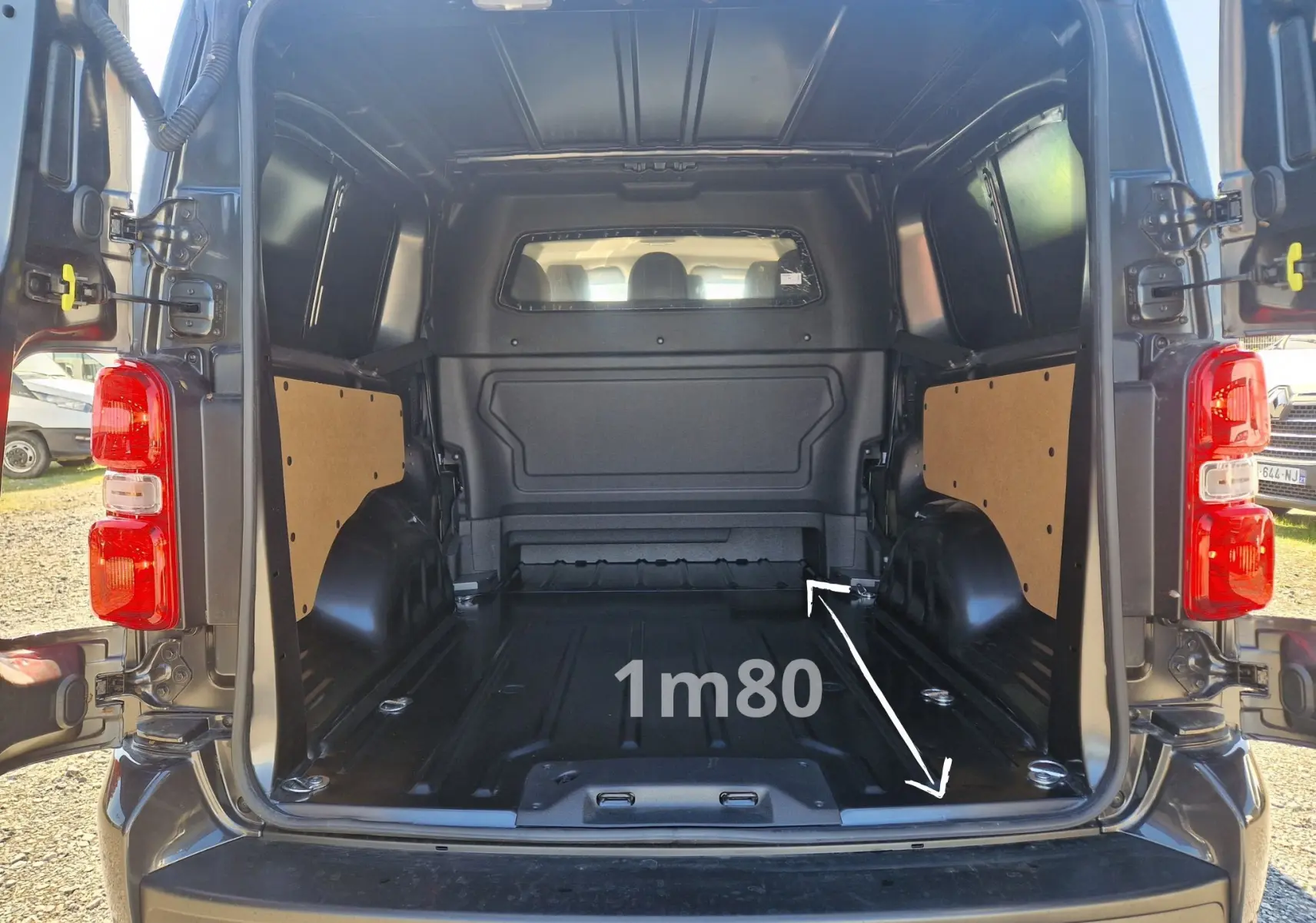 Coffre arrière ouvert du Peugeot Expert XL gris titane, vue intérieure montrant l’espace de chargement de 1,80 mètre.