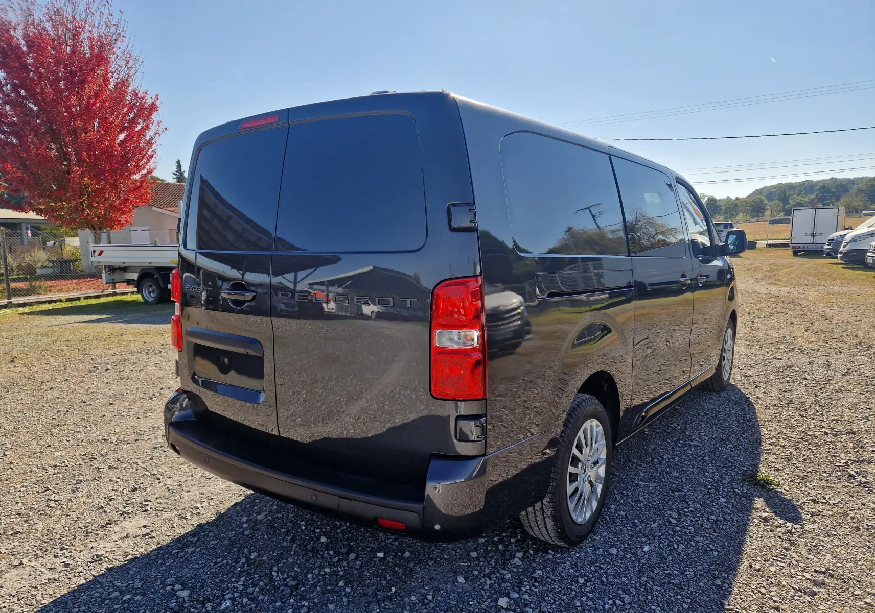 Vue 3/4 arrière droite d'un Peugeot Expert Cabine Approfondie gris titane, avec vitres teintées et feux arrière rouges.