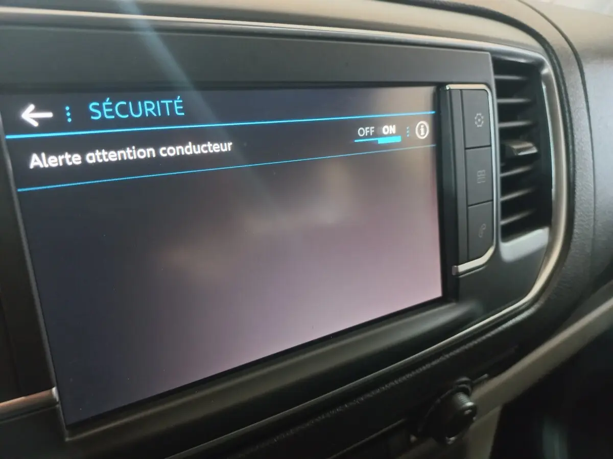 Écran tactile central du tableau de bord du Peugeot Traveller 2021 affichant le menu sécurité avec alerte attention conducteur activée.