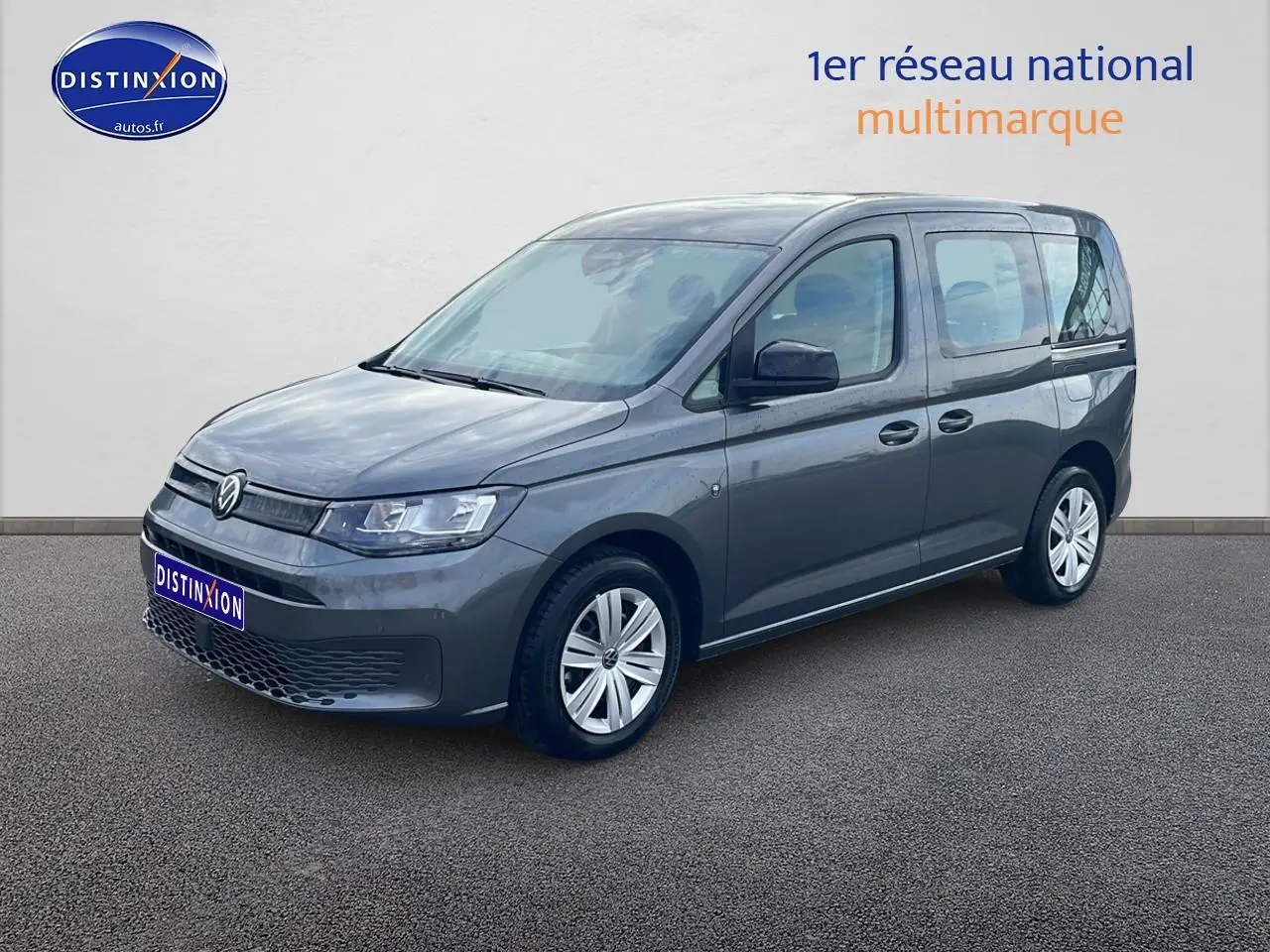 Vue 3/4 avant droit d'un Volkswagen Caddy gris indien avec jantes alliage et calandre épurée.