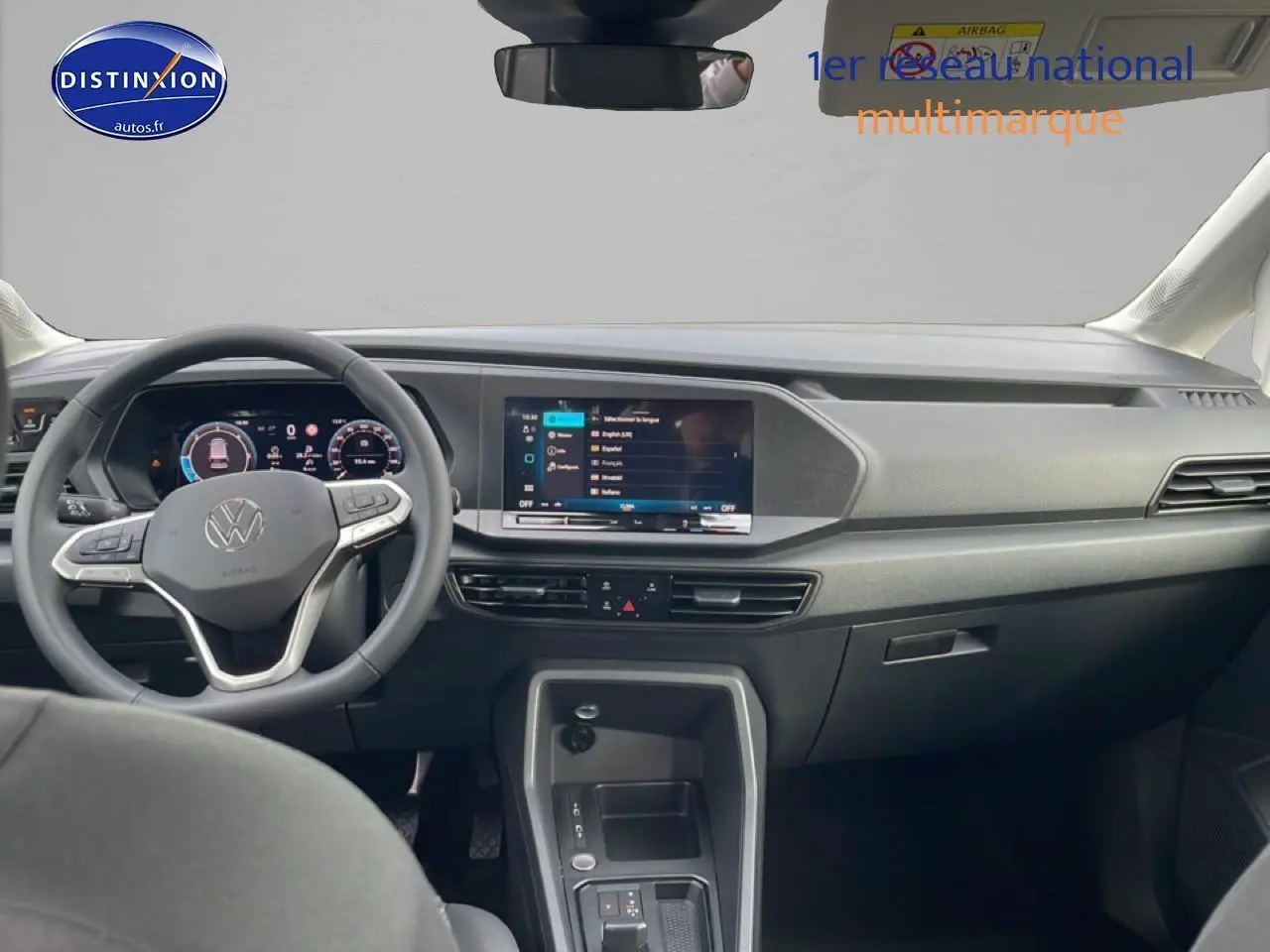 Vue intérieure avant du Volkswagen Caddy gris indien 2025, volant cuir multifonction et écran tactile 10 pouces.