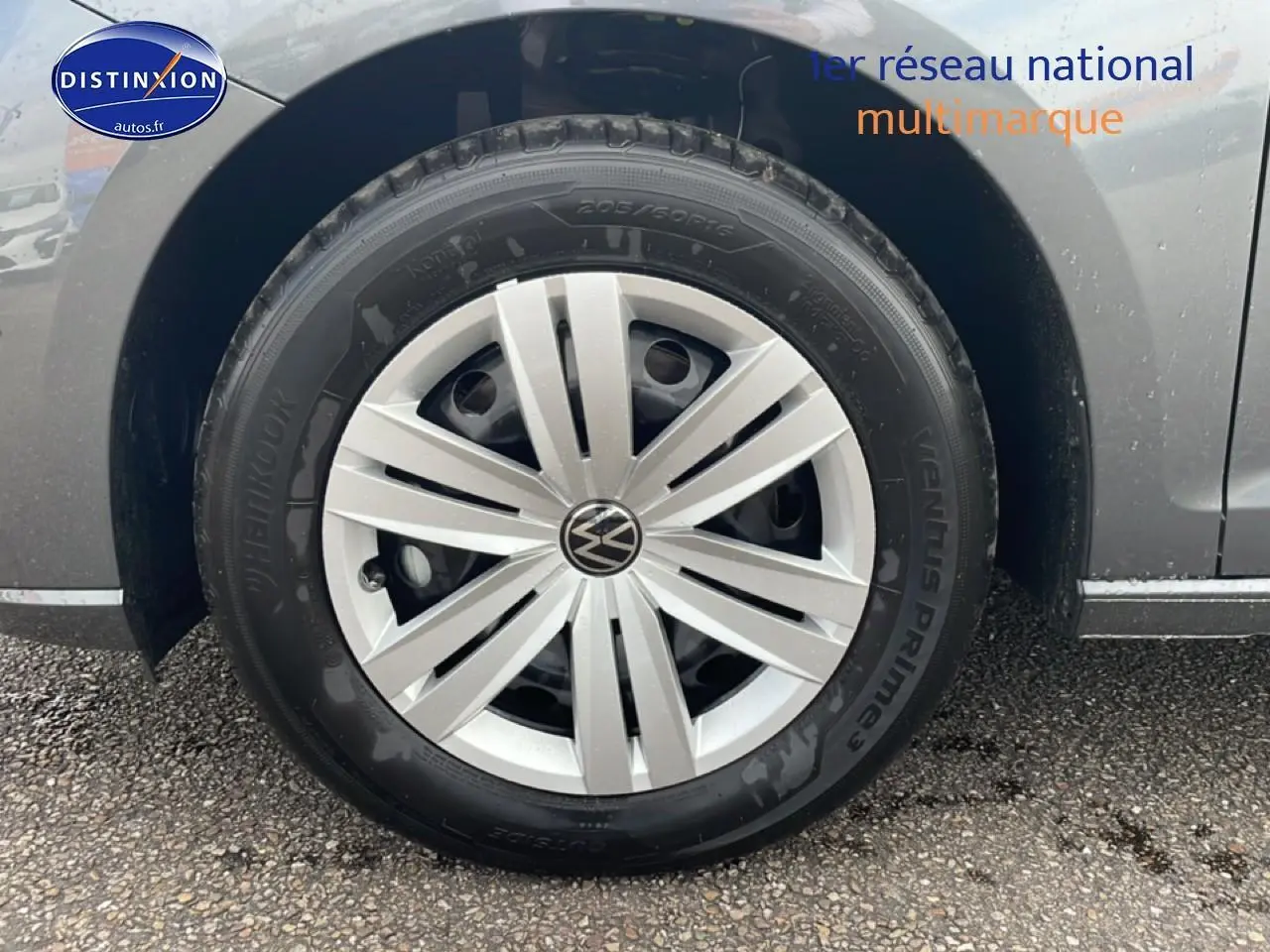 Gros plan sur la roue avant droite grise d'un Volkswagen Caddy 2.0 TDI 122 DSG7 avec jante argentée.