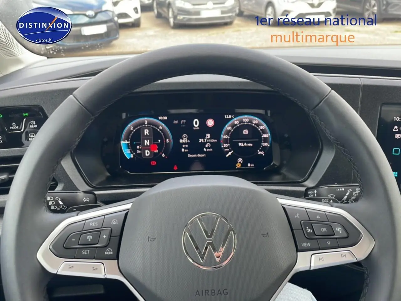 Vue intérieure centrée sur le volant cuir multifonction d’un Volkswagen Caddy gris indien avec tableau de bord numérique.