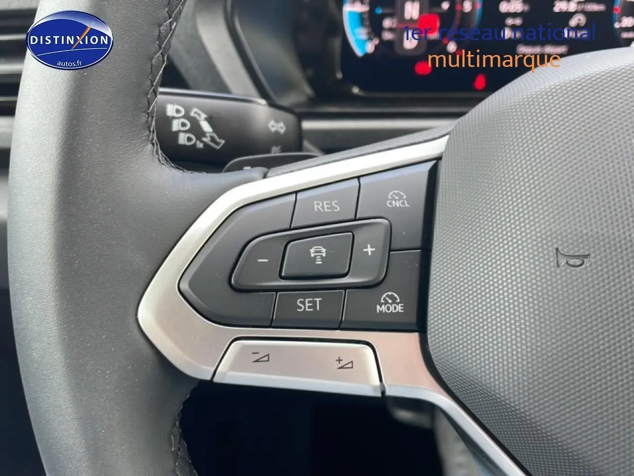 Gros plan sur les commandes multifonctions du volant cuir du Volkswagen Caddy gris indien, côté gauche.