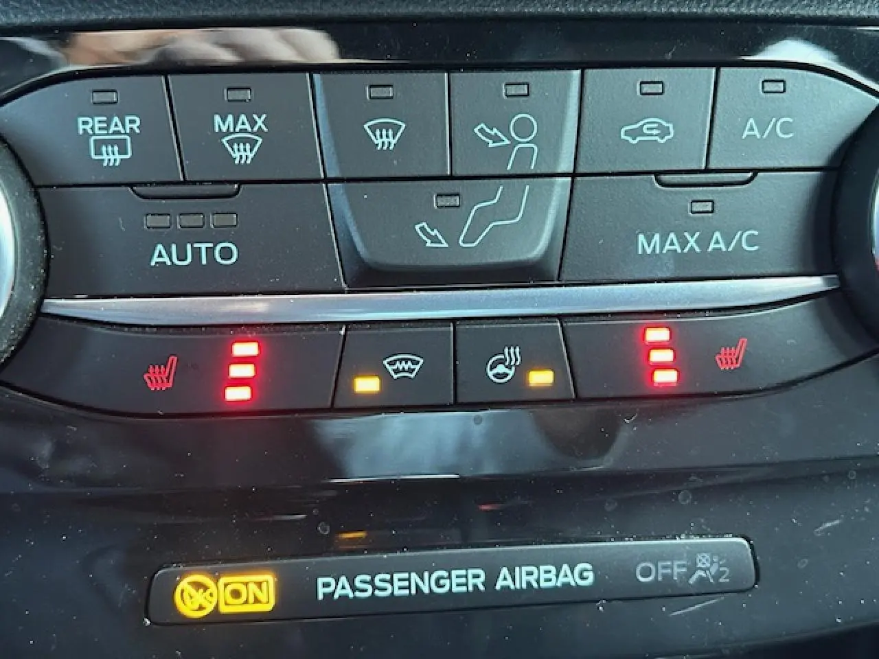 Gros plan sur la console centrale du Ford Puma gris Magnetic, affichant les commandes de climatisation et sièges chauffants.