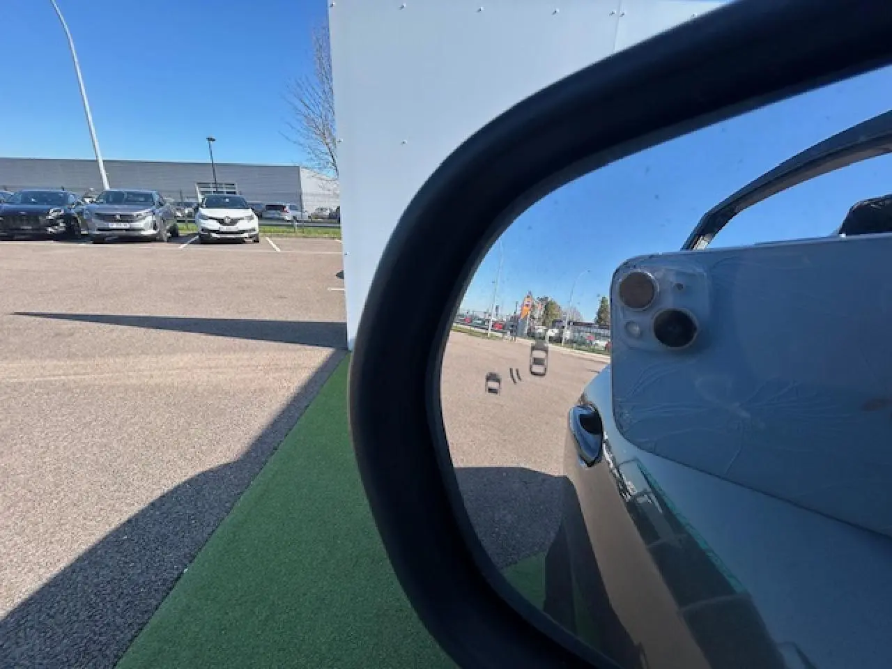 Reflet dans le rétroviseur côté droit d’un Ford Puma gris Magnetic, avec partie de la portière visible.