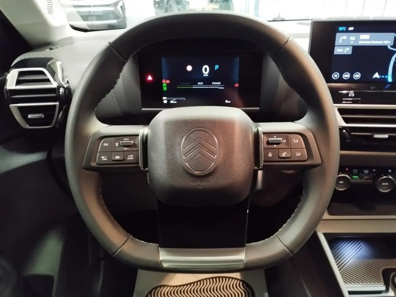 Vue frontale du volant cuir noir de la Citroën C4 2025 avec tableau de bord numérique et écran tactile central.