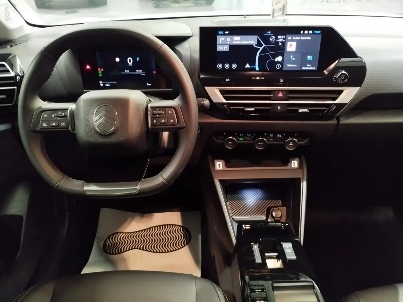 Vue intérieure frontale du tableau de bord et volant noir de la Citroën C4 2025 avec écran tactile et commandes intégrées.