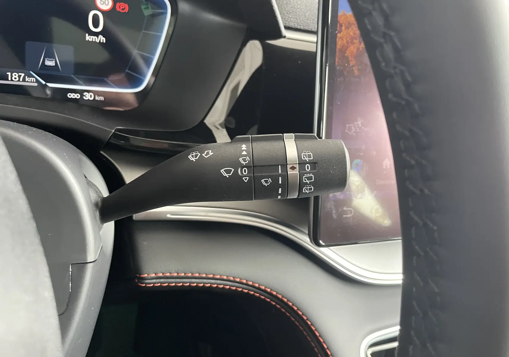 Gros plan sur la commande d’essuie-glace à gauche du volant dans l’habitacle noir du BYD SEAL U 2025.