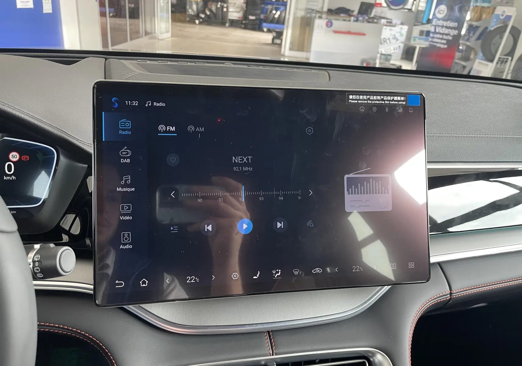 Vue rapprochée de l'écran tactile central du tableau de bord du BYD SEAL U 2025, avec affichage radio et détails intérieurs noirs et gris.