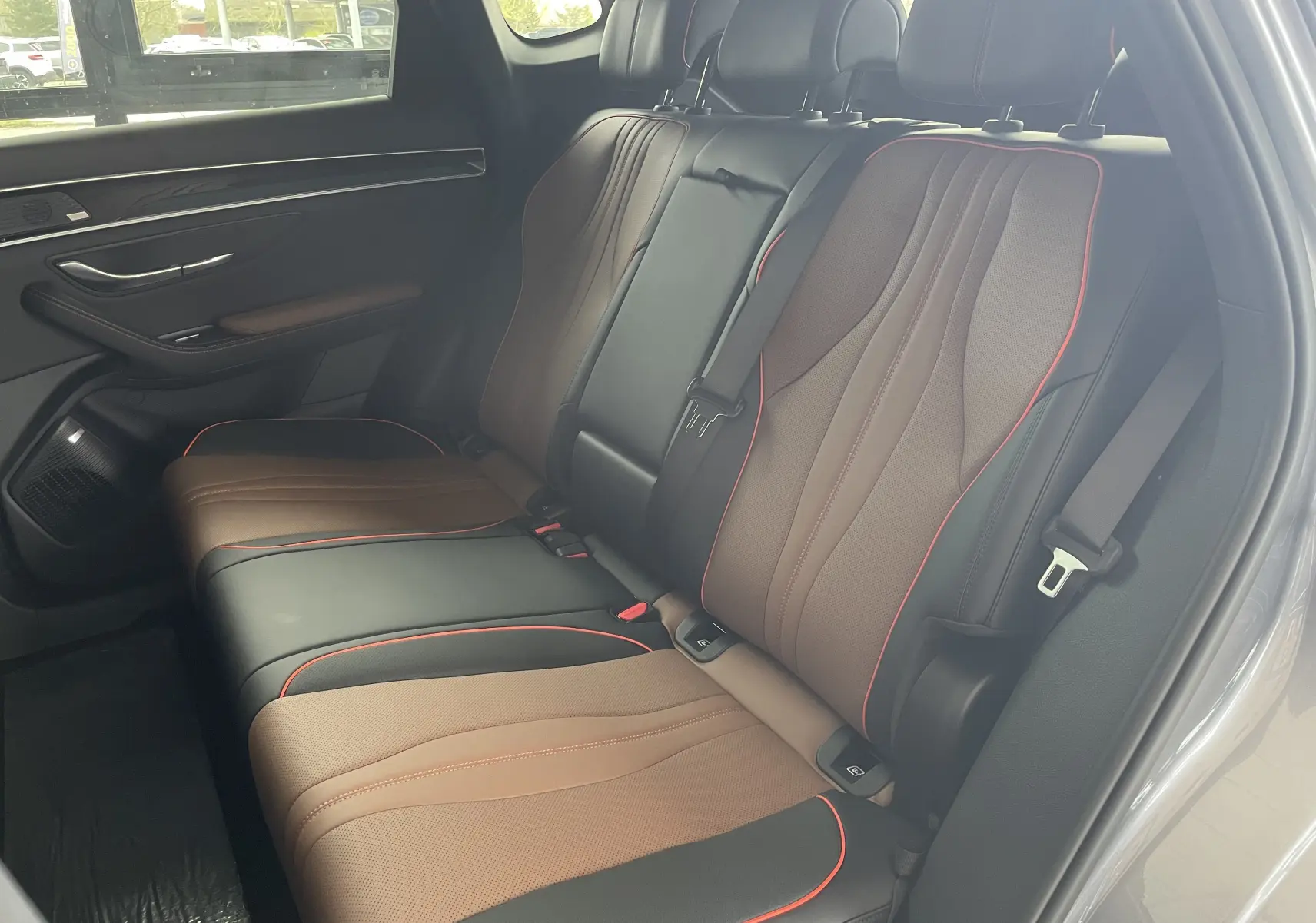 Vue intérieure côté droit des sièges arrière en similicuir noir et brun avec surpiqûres rouges du BYD SEAL U 2025.