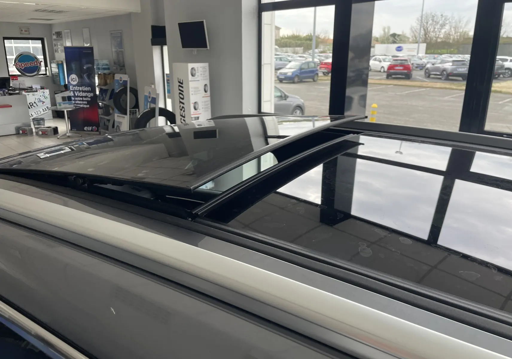 Toit ouvrant panoramique partiellement ouvert sur le dessus gris TIME GREY du BYD SEAL U en concession.