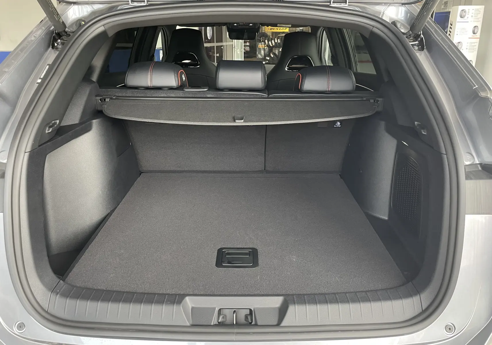 Coffre ouvert vu de l'arrière du BYD SEAL U gris TIME GREY avec banquette arrière et cache-bagages visibles.