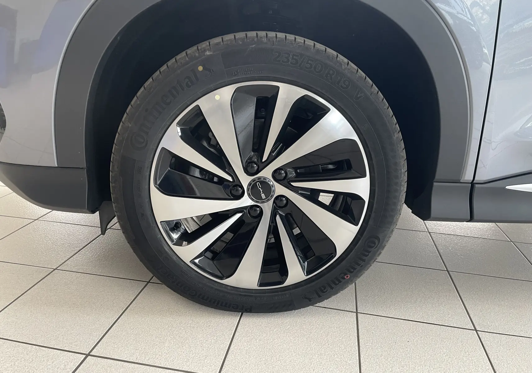 Gros plan sur la roue avant gauche du BYD SEAL U 2025 TIME GREY avec jante alliage bicolore 19 pouces.