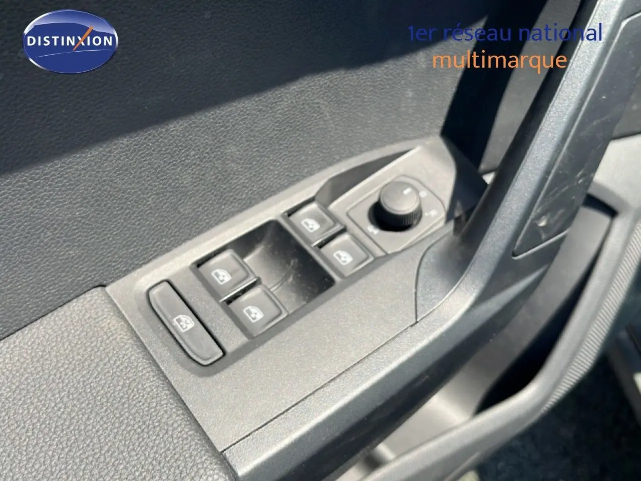 Gros plan sur les commandes des vitres électriques et rétroviseurs côté conducteur d'une SEAT Arona gris Magnetic Metal.