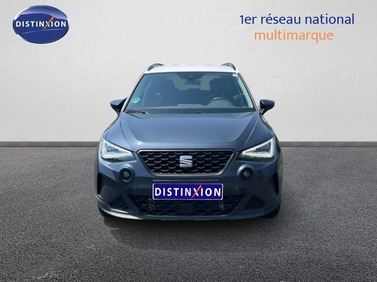 Vue frontale d'un SEAT Arona gris Magnetic Metal avec toit blanc, mettant en valeur ses phares LED et sa calandre noire.