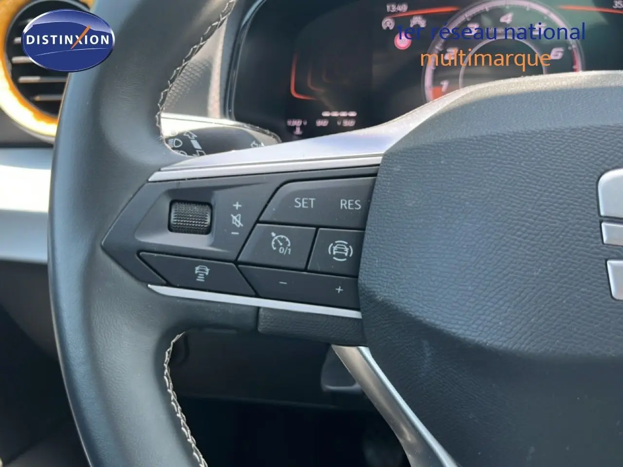Gros plan sur le volant multifonction noir de la SEAT Arona 2025 avec commandes de régulateur de vitesse.