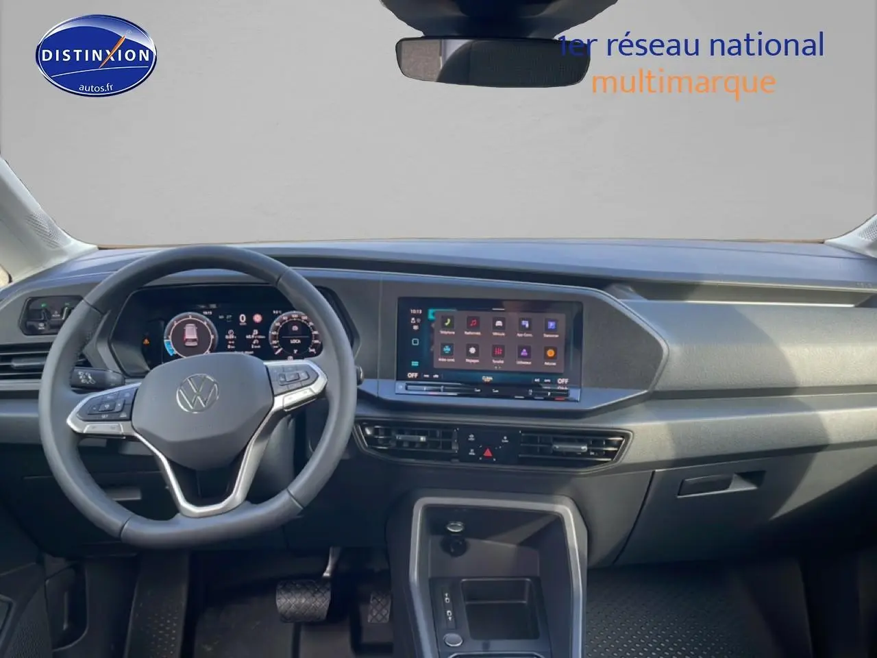 Vue intérieure frontale du tableau de bord du Volkswagen Caddy 2025 avec écran tactile et volant multifonction cuir.