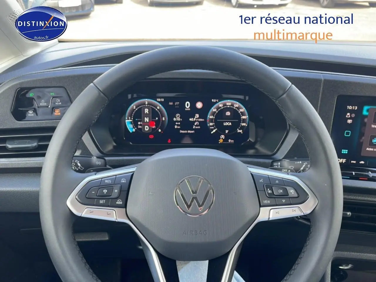 Vue intérieure centrée sur le volant cuir multifonction et l'instrumentation numérique du Volkswagen Caddy blanc 2025.