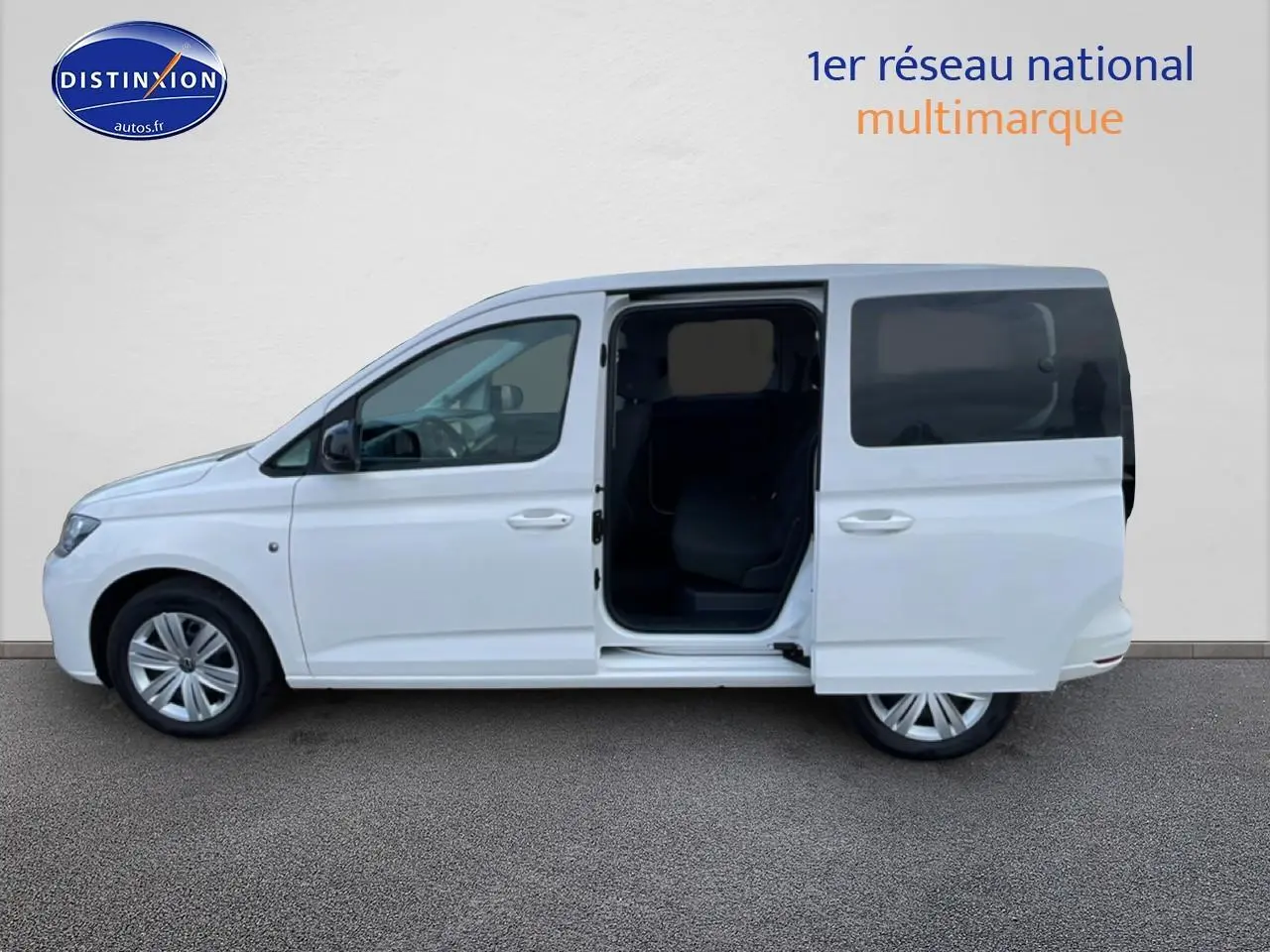 Vue de profil côté gauche d'un Volkswagen Caddy blanc 2025 avec porte coulissante arrière ouverte.