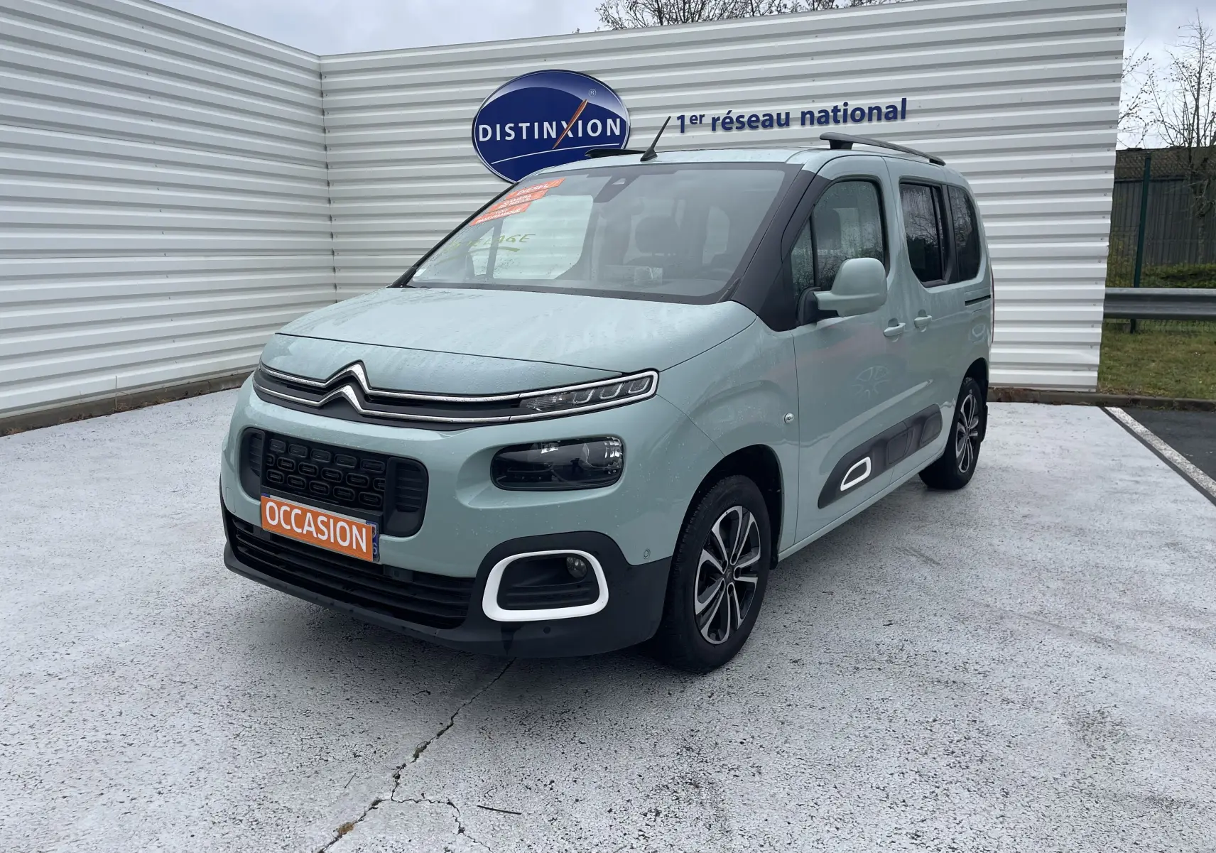 Citroën Berlingo M BlueHDi 130 Shine vert clair, vue 3/4 avant droit avec protections latérales noires et jantes bi-ton.